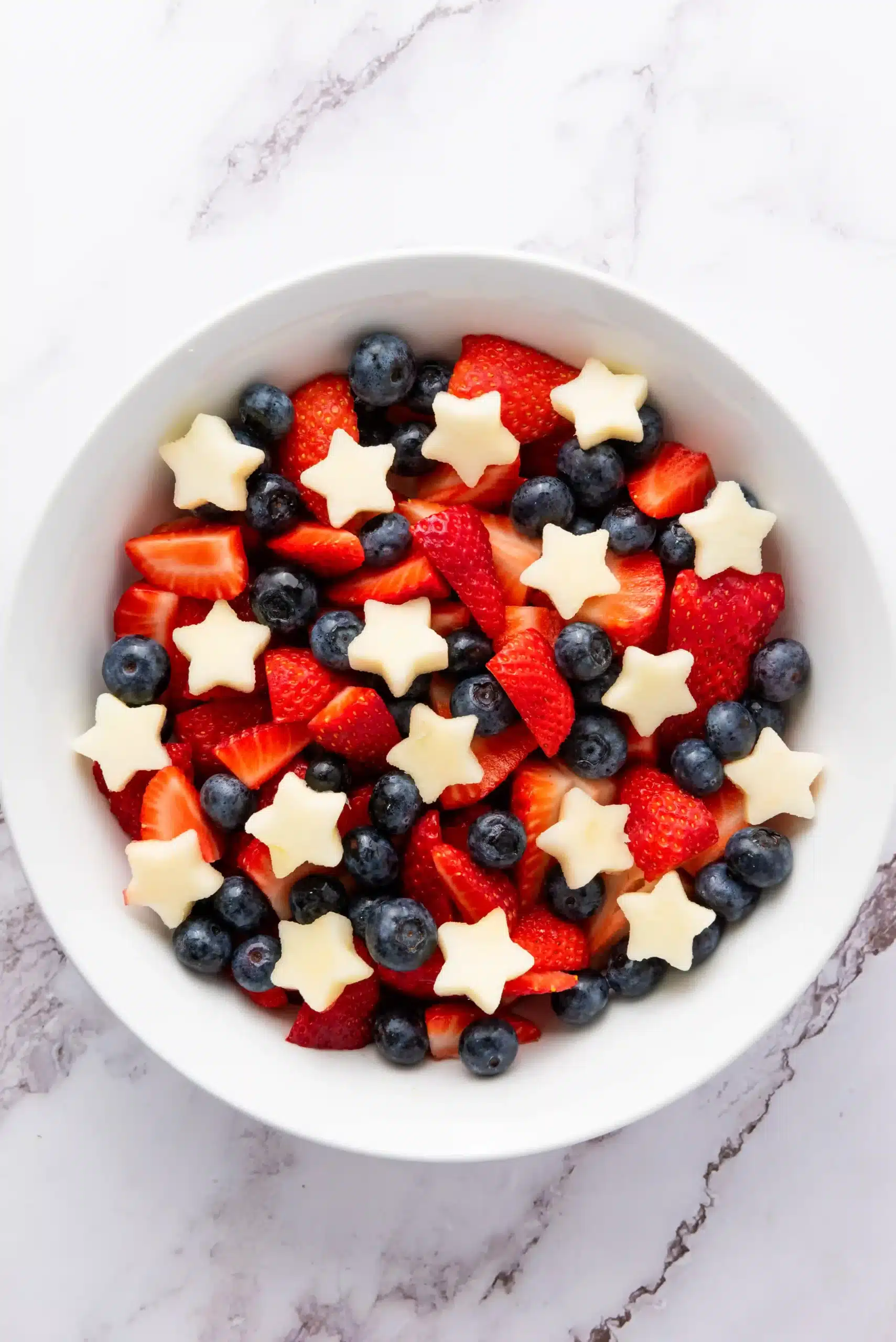 strawberries, blueberries, and apples cut into stars for a patriotic fruit salad