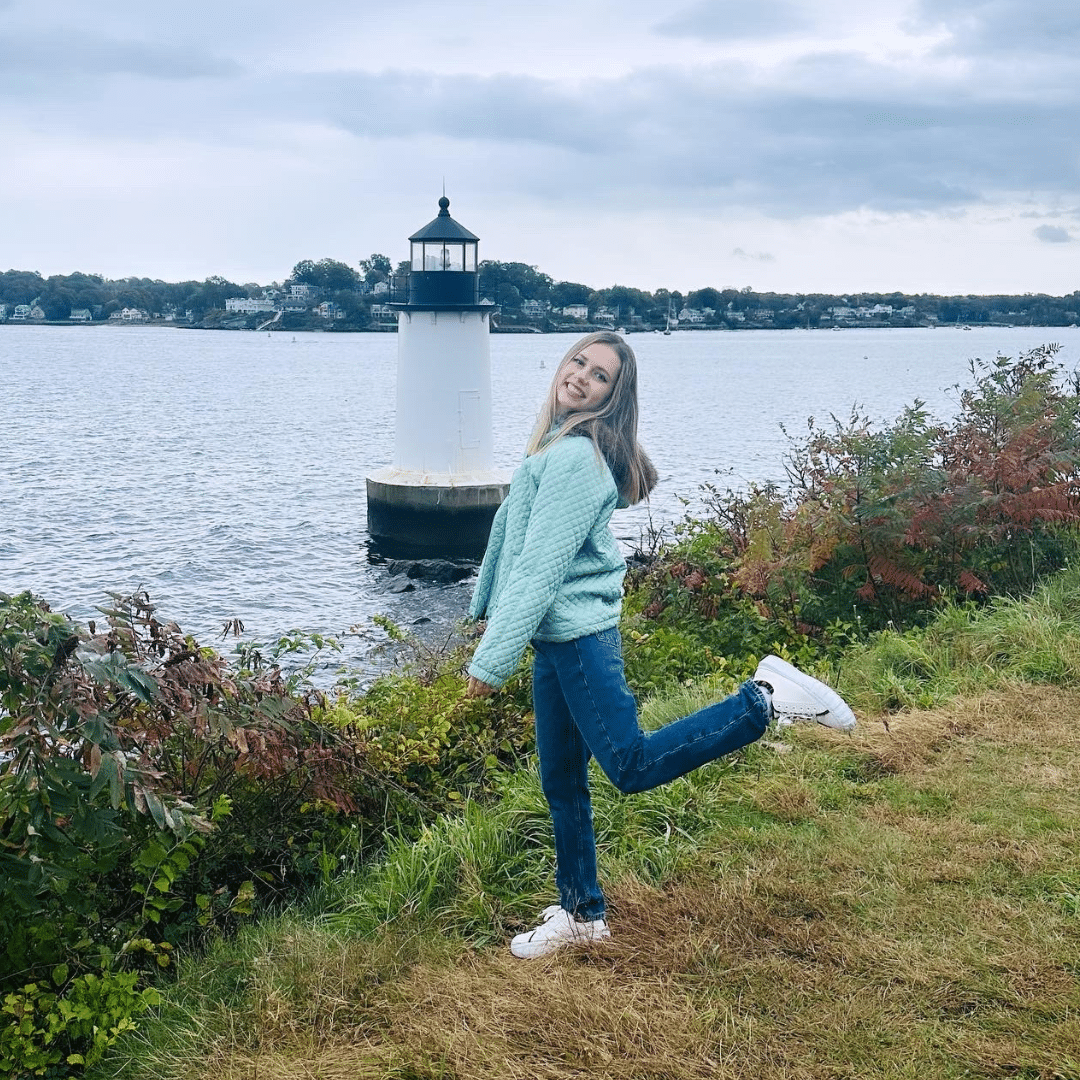 a photo of a girl in front of a lighthouse